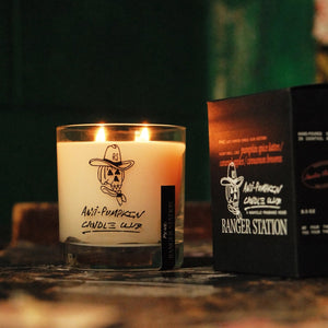 Candle with a label and a box on a dark background