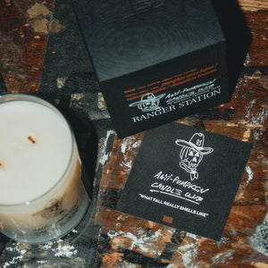 Candle and branded cards on a rustic wooden surface